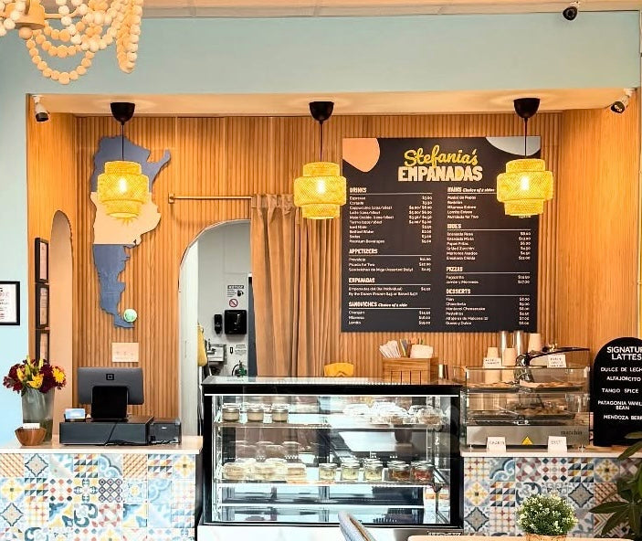 custom menu board with logo and brand colors on wall behind counter restaurant cafe store interior