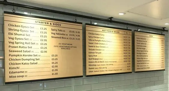 Custom printed menu boards hanging from a bar in a restaurant.