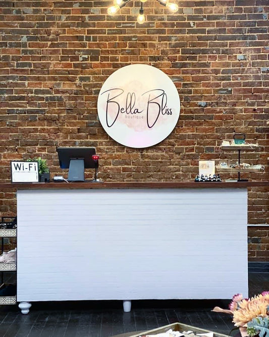 custom round business logo sign for boutique store interior on brick wall - Bella Bliss example