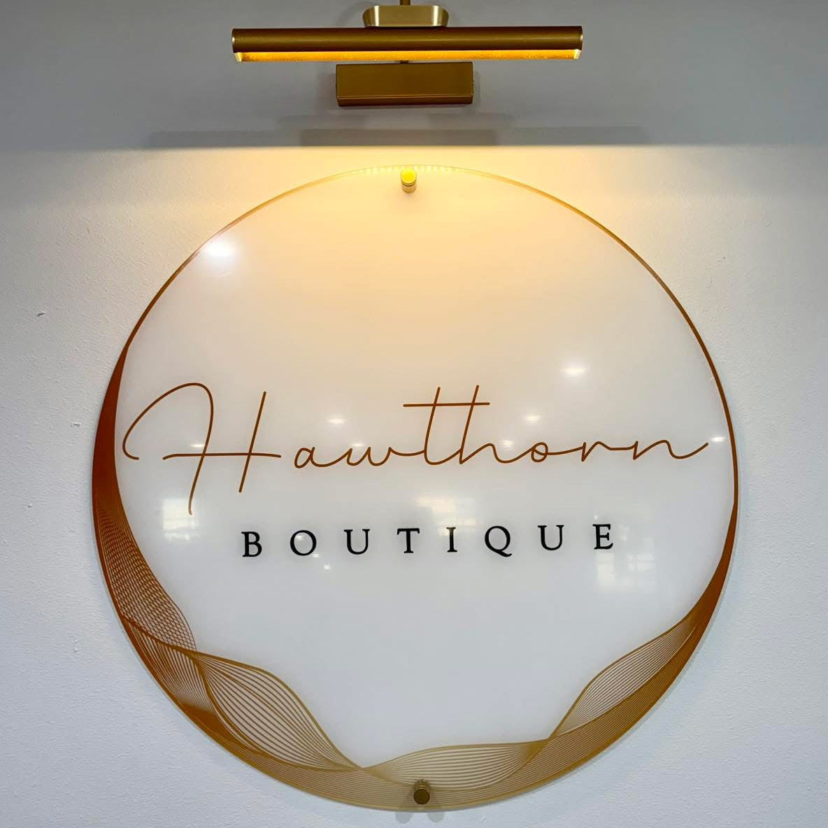 round acrylic business logo boutique sign on wall with standoffs and light