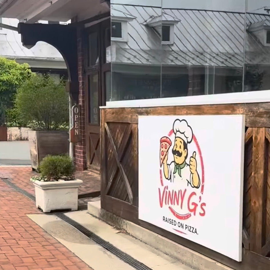 pizza restaurant sign custom logo outdoor on a wooden wall with a building in the background